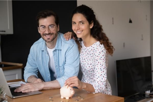 Couple sitting at computer looking at camera 